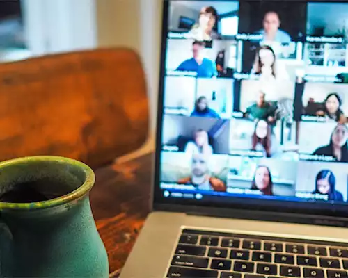 A mug of coffee with a webinar in the background