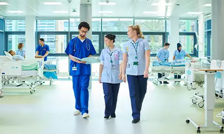 A group of doctors and nurses on a hospital ward in the UK looking at a clipboard