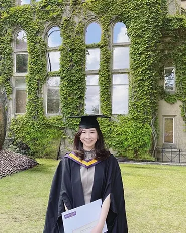 student in front of building graduation