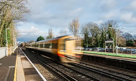 A train speeding through an empty station in Surrey.