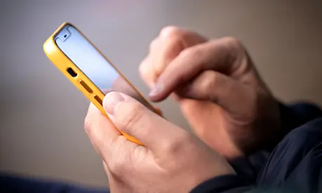 A person typing on a smartphone.