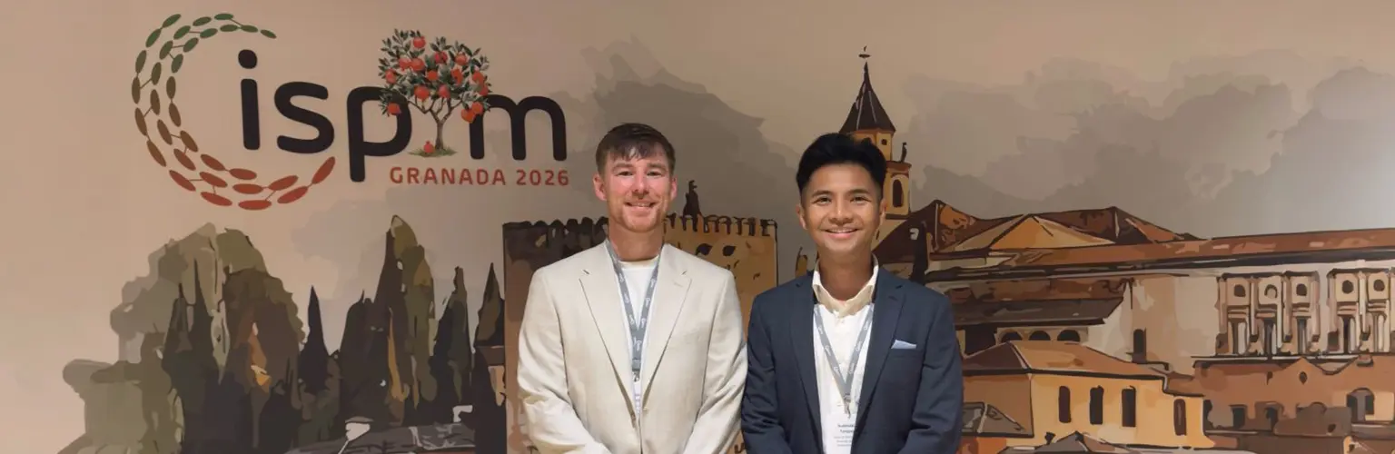 Tom and Aaron standing together in front of an ISPN banner.