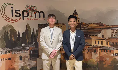 Tom and Aaron standing together in front of an ISPN banner.