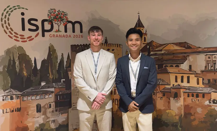 Tom and Aaron standing together in front of an ISPN banner.
