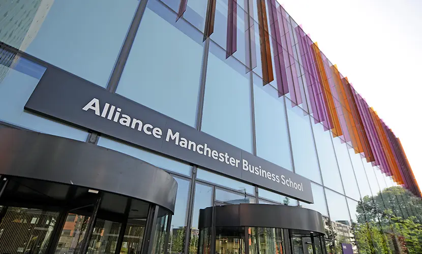 Alliance Manchester Business School entrance with purple and orange glass panels.