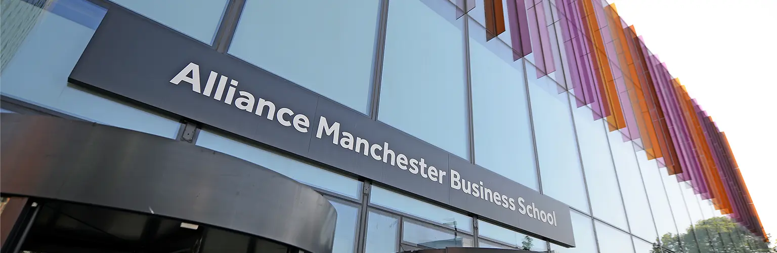 Alliance Manchester Business School entrance with purple and orange glass panels.