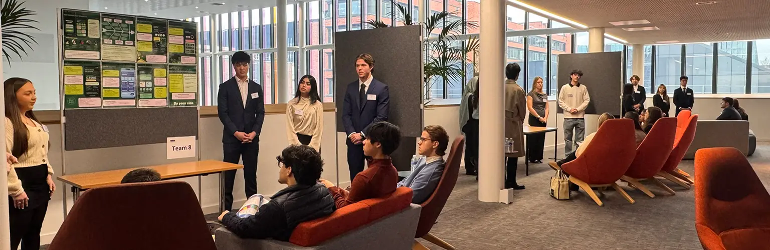 ITMB and MSc Digital Transformation students presenting project posters to employers at the AMBS ITMB Showcase, with small audiences seated in a modern open space.
