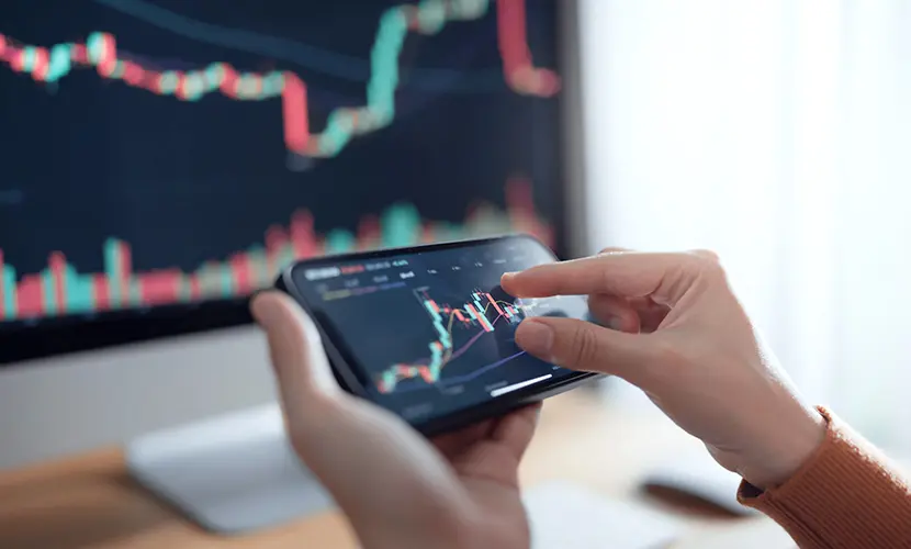 Investors analyse the data stock market index via smartphone screen.