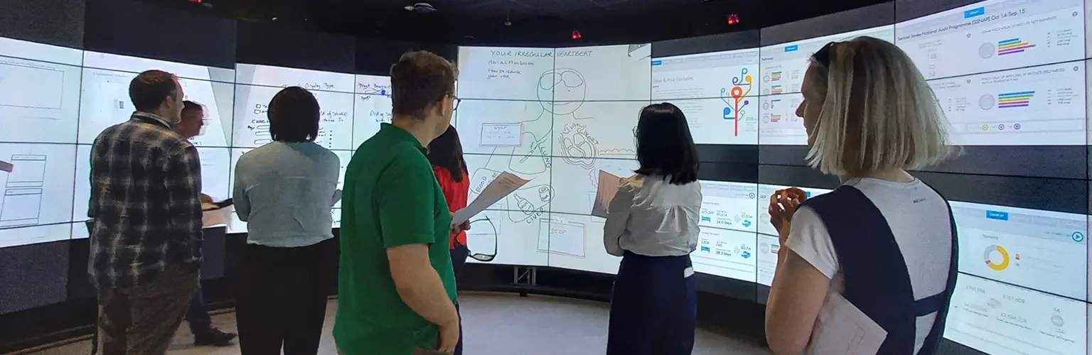 Clinical Data Science students looking at data on large screens.