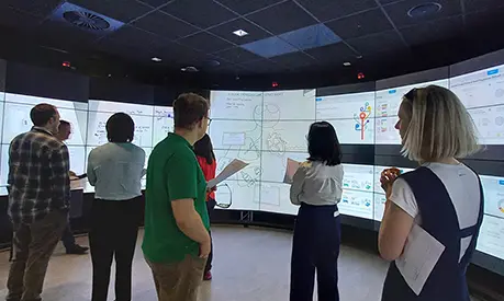 Clinical Data Science students looking at data on large screens.