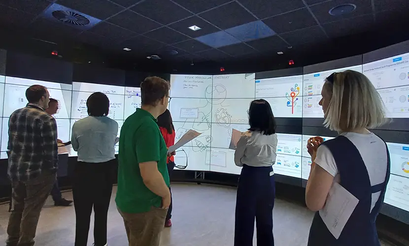 Clinical Data Science students looking at data on large screens.