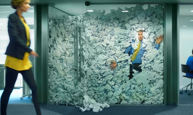 Man squashed in office with too much paper