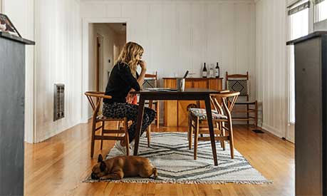 A woman sitting on a desk at home