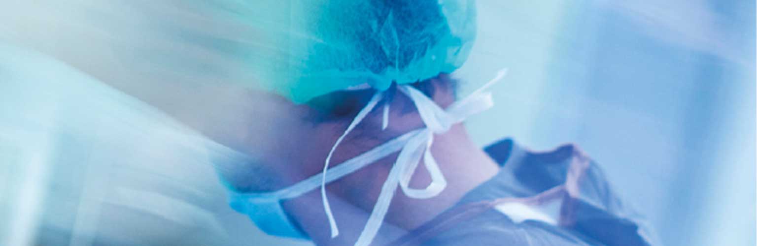 A healthcare worker in a surgical mask and scrubs