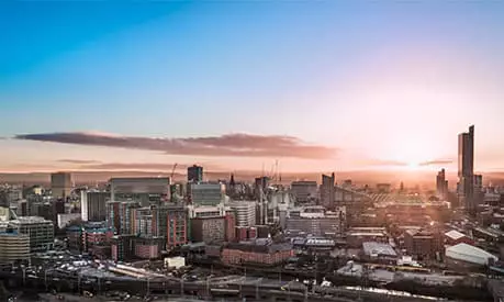 A cityscape of Manchester in the sunset