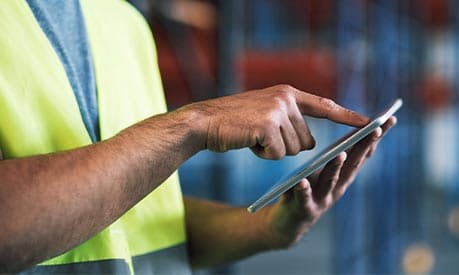 An employee using an ipad in a warehouse