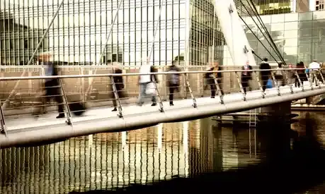 Commuters crossing a bridge in London's Finance District
