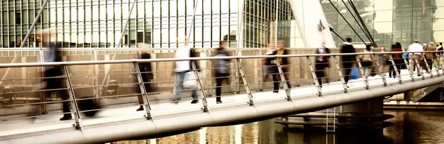 Commuters crossing a bridge in London's Finance District