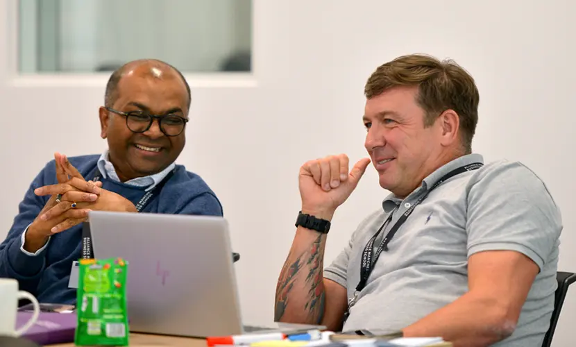 Two business professionals sat around a table discussing project work