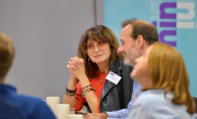 A group of senior professionals sitting together in a classroom environment