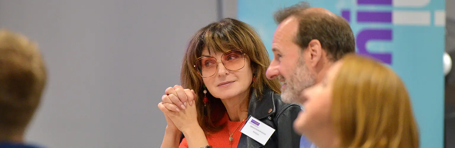 A group of senior professionals sitting together in a classroom environment