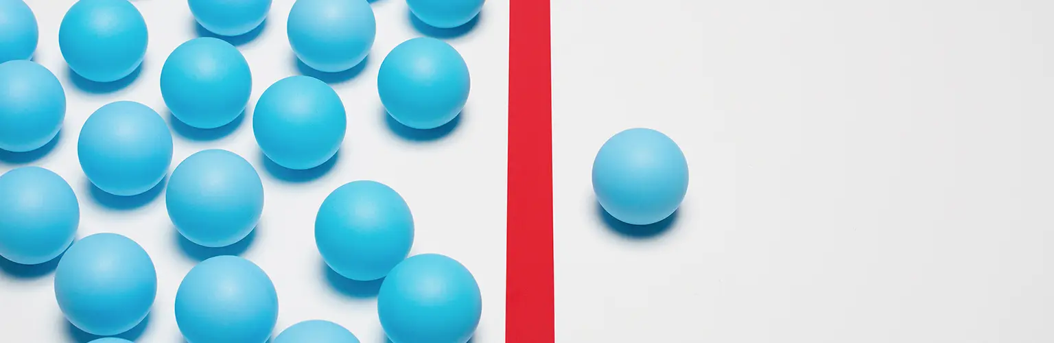 One blue ball on one right side of red line, many blue balls on left side.
