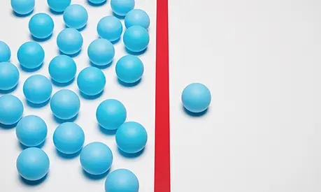 One blue ball on one right side of red line, many blue balls on left side.