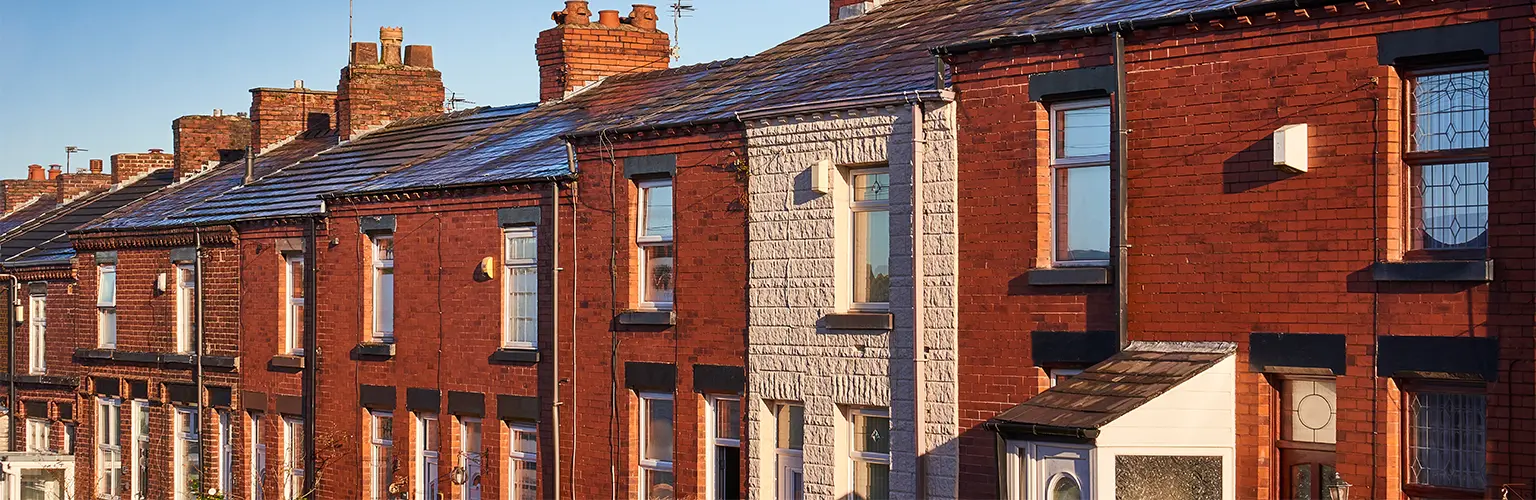 A row of terraced houses on a street in Northwest England.