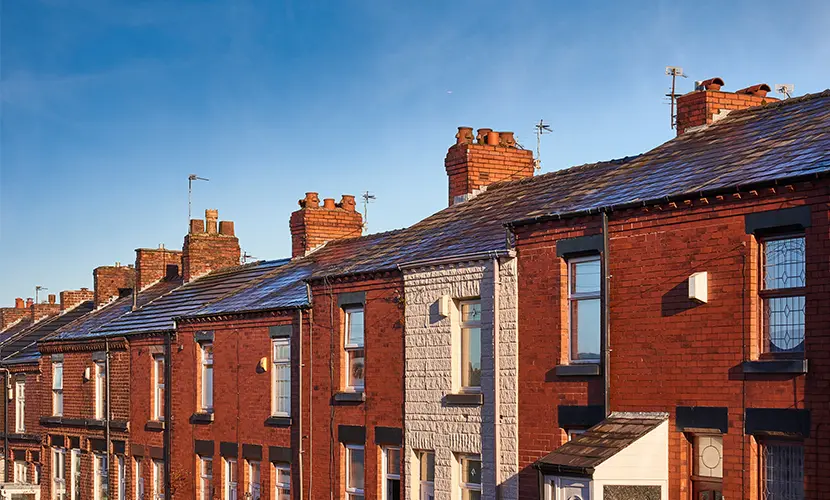 A row of terraced houses on a street in Northwest England.
