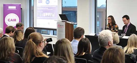 A seminar event at Alliance MBS with two speakers in front of an audience.