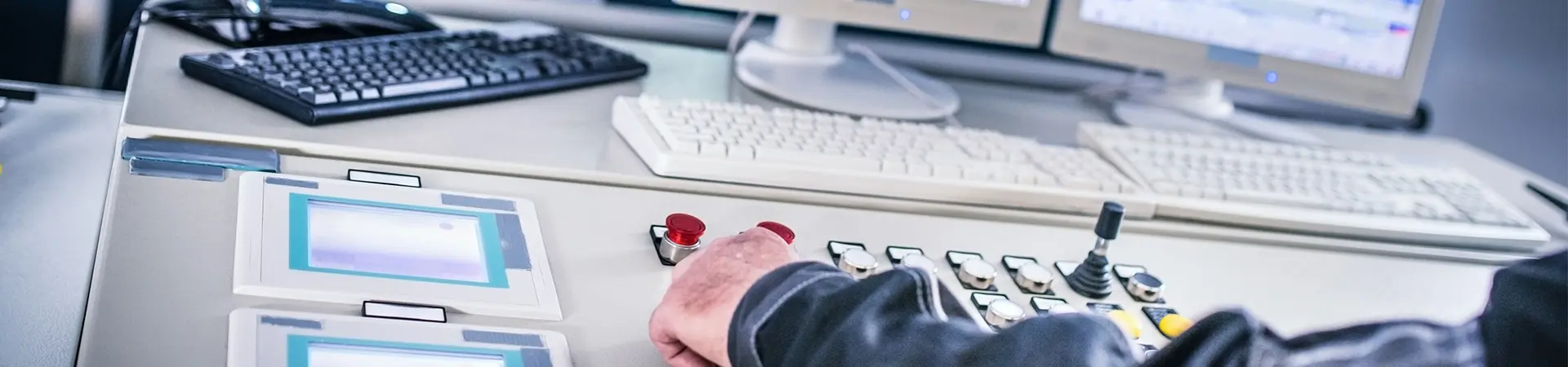 Finger on emergency button in control room.