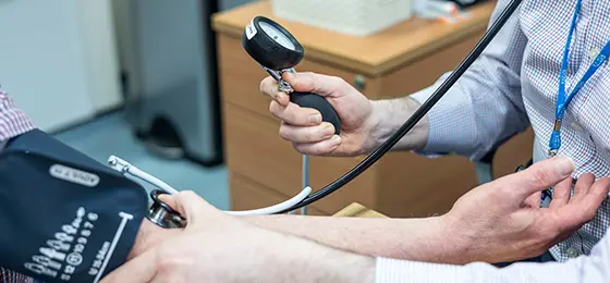 Doctor taking blood pressure reading for a patient.