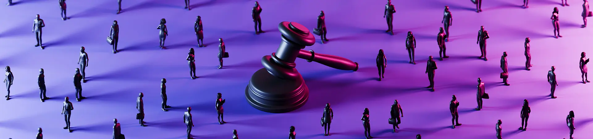 Judge's gavel in the centre of the image surrounded by small figurines representing people.