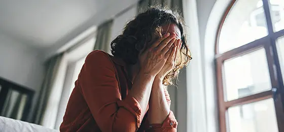A stressed woman with her head in her hands.