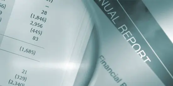A magnifying glass looking at a paper financial report