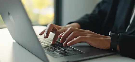 A close up of a person typing on a laptop.
