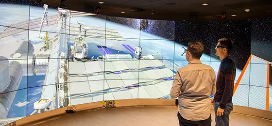 Two people looking at screens in the Data Visualisation Observatory.