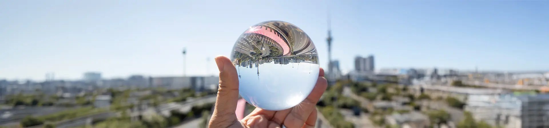 Hand holding crystal ball in front of motorway and cityscape