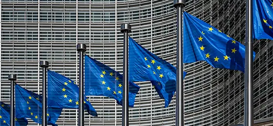 European flags in front of headquarters of European commission in Brussels on a summer day.