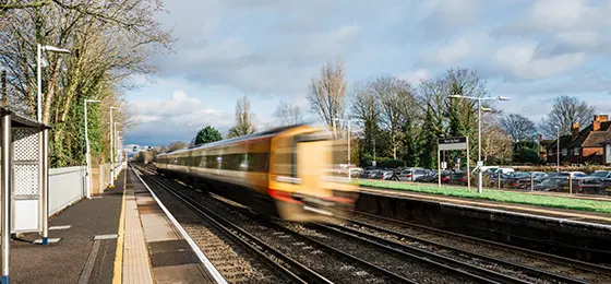 A train speeding through an empty station in Surrey.