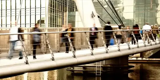Commuters crossing a bridge in London's Finance District