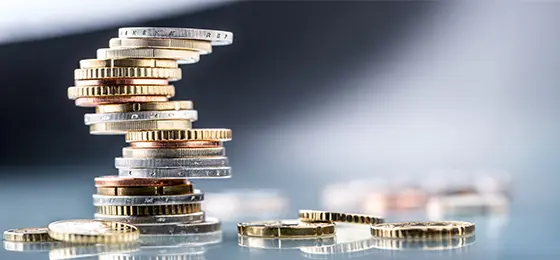 Euro coins built in the shape of a tower that balances before falling.