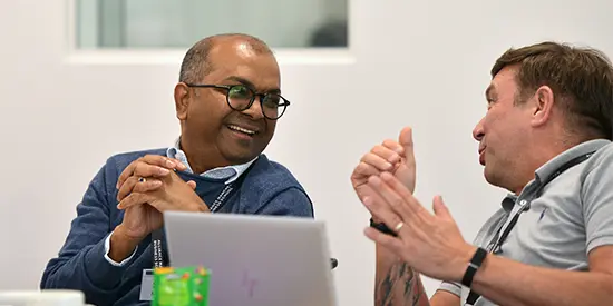 Two executive education delegates talking during a workshop.