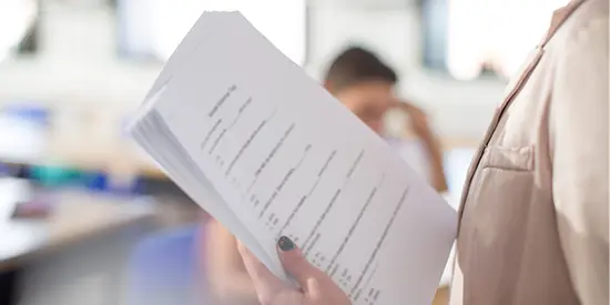 Teacher with test notes in classroom.