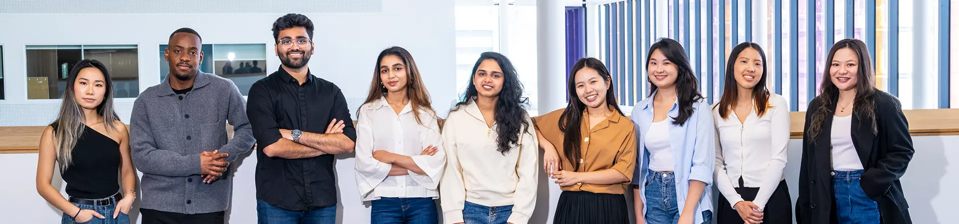 A group of diverse master's students standing in a line.