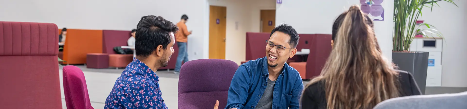 Two male masters students having a conversation in a communal study space at Alliance MBS.